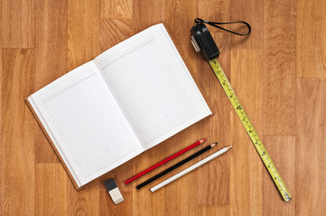 Blank notepad with office supplies on wooden table.