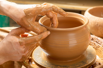 hands of a potter, creating an earthen jar