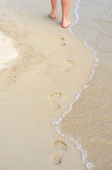 Women's legs beach footprnts