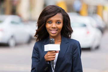 female african news reporter working outdoors - obrazy, fototapety, plakaty
