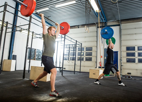 Athletes Exercising With Barbells