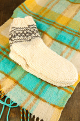 Fototapeta na wymiar Warm knitted socks on plaid close-up
