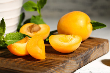Ripe apricots with green mint leaves