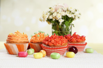 Tasty cupcakes on table, on bright background