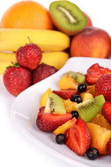 Fresh fruits salad on plate with berries close up