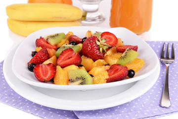 Fresh fruits salad in bowl with berries and juice close up