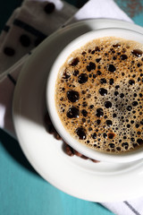 Cup of coffee on color wooden background