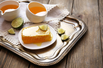 Fresh honey snack on tray on wooden table