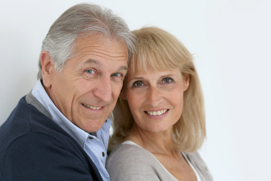 Portrait of senior couple embracing each other, isolated