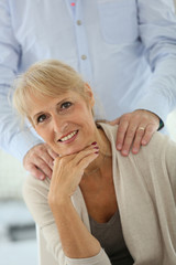 Fototapeta premium Portrait of senior woman with husband's hand on shoulders