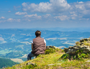 Naklejka na ściany i meble Woman sitting and looking at the Carpathian Mountains