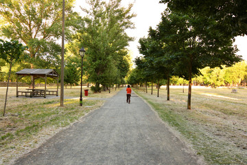 mujer caminando por un parque urbano