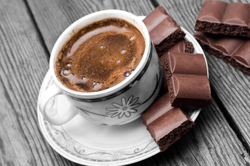 cup with hot coffee and chocolate on a table