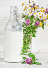 Fresh milk in old fashioned bottle and wildflowers