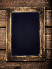 Aged  menu blackboard over vintage wooden background. Empty Chal