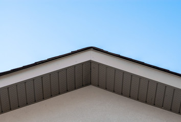 Top of house roof edge on clear sky.