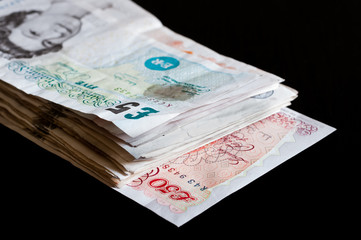 Pile of money british pounds sterling gbp isolated on black for