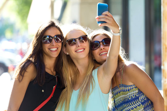 Group of friends taking selfie in the street.