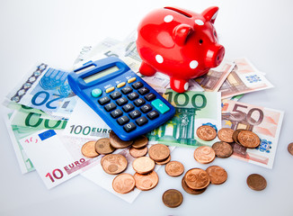 Red piggy bank with calculator and money.