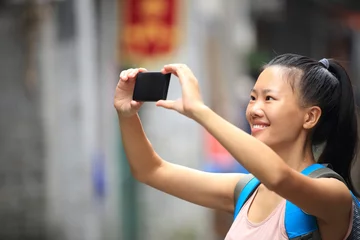 Gordijnen woman tourist taking photo with smart phone in guilin,china  © lzf