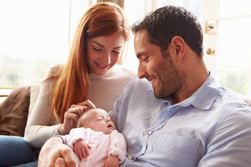 Mother And Father At Home With Newborn Baby