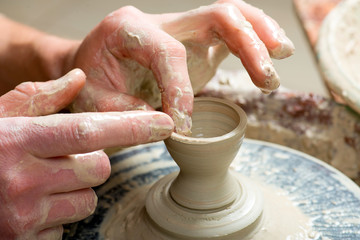 hands of a potter, creating an earthen jar