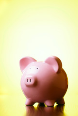 Pink piggy bank on a bright yellow background