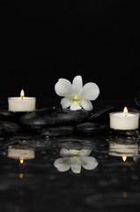 Fototapeta na wymiar White orchid with two candle and therapy stones