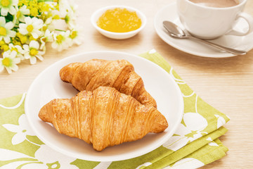 Croissants and coffee cup on table, filtered image