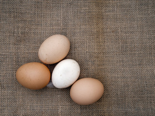 Farm fresh eggs assorted colours, on hessian old rustic fabric