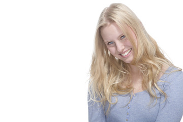 Junge blonde Frau lächelt gegen weisser Hintergrund