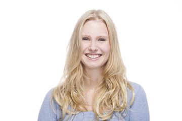 Junge blonde Frau lächelt gegen weisser Hintergrund