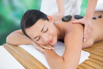 Fototapeta na wymiar Beautiful brunette enjoying a hot stone massage