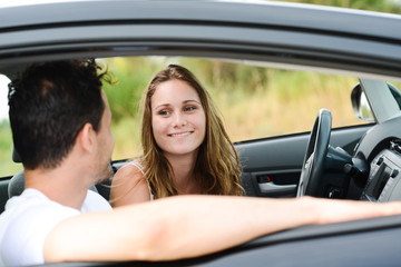 happy young couple driving new car on holiday trip in summer