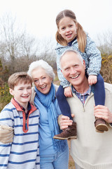 Grandparents With Grandchildren On Walk In Countryside