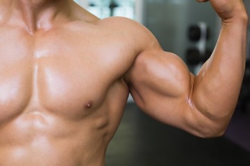 Mid section of muscular man flexing muscles - Powered by Adobe