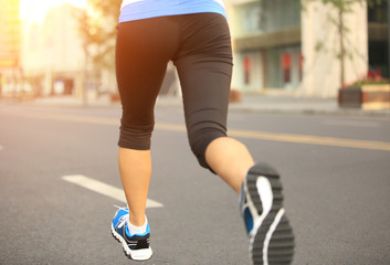 Runner athlete running on city road.  