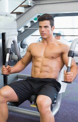 Fototapeta na wymiar Muscular man working on abdominal machine at the gym
