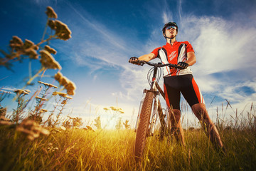 man is riding bicycle outside in the field