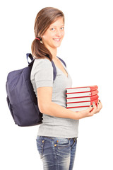 Teenage schoolgirl holding a stack of books