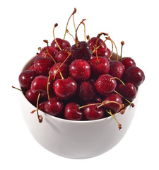 Red cherries in a white bowl on a white