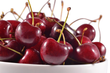 Red cherries in a white bowl close up