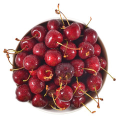 Obraz na płótnie Canvas Top view of red cherries in a white bowl on a white