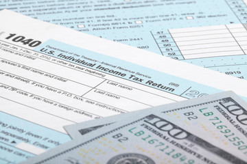USA Tax Form 1040 with 100 US dollar bills