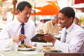 Two Businessmen Having Meeting In Outdoor Restaurant