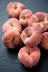 Close-up of a stack of flat peaches, vertical shot