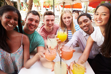 Group Of Friends Enjoying Drinks In Outdoor Restaurant