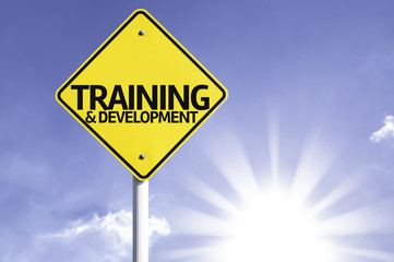 Training & Development road sign with sun background