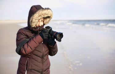 Female photographer on winter beach