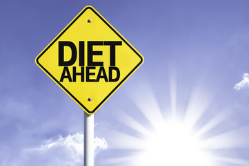 Diet Ahead road sign with sun background